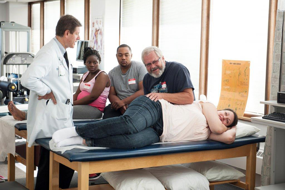 DO teaches pregnant women's partners manual therapy