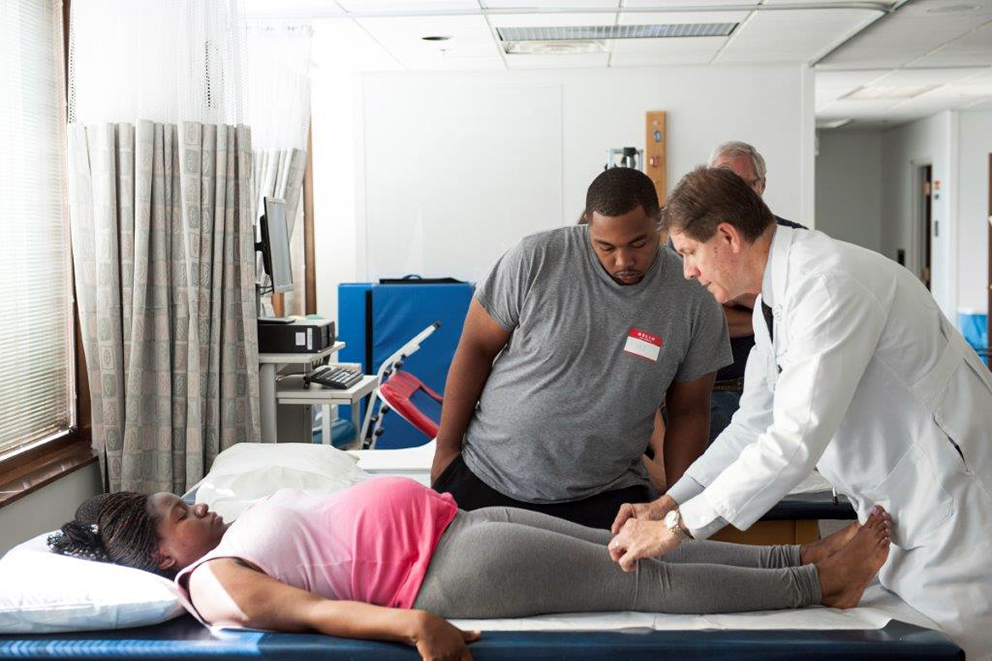 DO teaches pregnant women's partners manual therapy